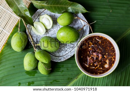Green mango with sweet fish sauce on green leaf, Thai popular food, Selective focus Royalty-Free Stock Photo #1040971918