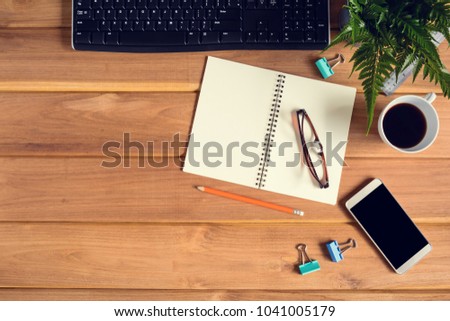 top view desk wood and office equipment with hot tea afternoon and decorative tree