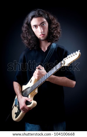 Guitar player against the dark background