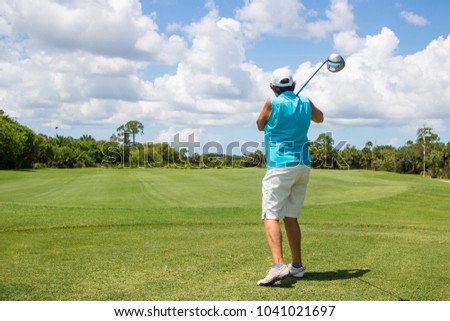 Retired female golfer hitting a ball on a beautiful golf course
