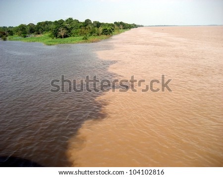 Meeting of the Rio Acuruí, (black water) and the Rio Solimoes (muddy water) at Amaturá in the Amazon, Brazil Royalty-Free Stock Photo #104102816