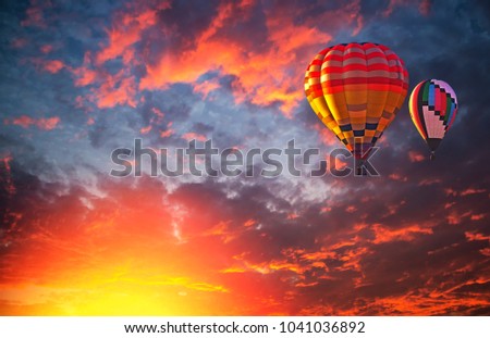 Hot air balloon flying over dramatic sky and colorful clouds