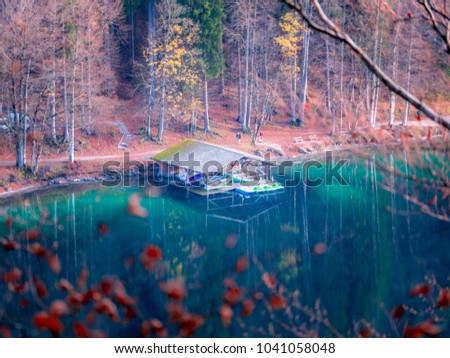 Zoom on a boatshouse in a lake in Autumn with colourful trees and Water Reflections   Royalty-Free Stock Photo #1041058048