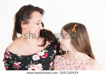 bright picture of hugging mother and daughter happy together, smiling stylish family looking each other
