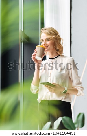 Photo of amazing young business woman in office looking aside chatting by mobile phone drinking coffee.