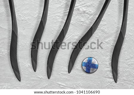 Finnish washer and five sticks on the ice hockey arena. Concept, hockey