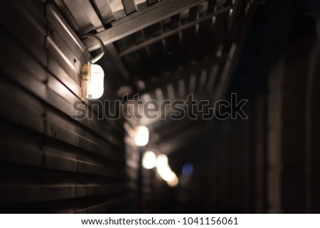Metal tunnel with lamps. Dark picture