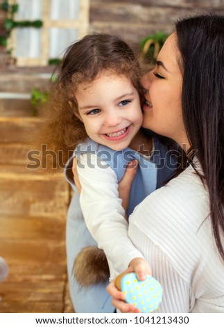 Happy loving family. mother and child playing, kissing and hugging on Mother Day. Cute curly girl smiling with pretty mother