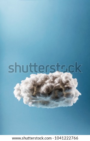 Single cloud on a light blue background. Weather or digital cloud concept. Cotton handmade.