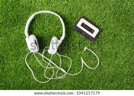 White headphones on a green grass. Top of view