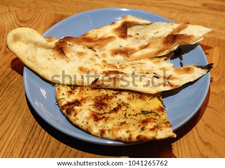 Tasty Indian flatbread on plate in restaurant take close up picture