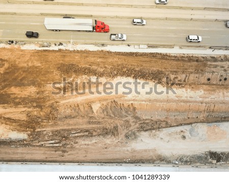 Aerial view construction of elevated highway in progress in Houston, Texas, USA. Workers and heavy machinery joining the various blocks, modules of the overpass line. Industrial background