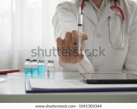 hand in glove with syringe on white