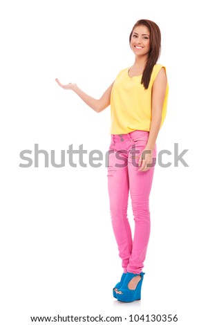full body picture of a happy young casual woman showing something on the palm of her hand, against white background