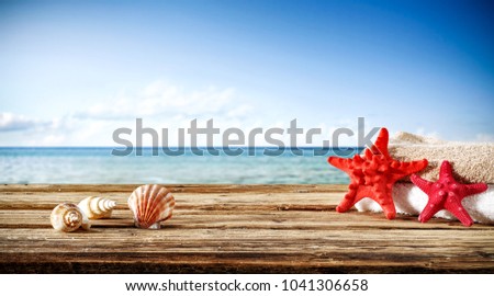 Summer photo of wooden desk and travel tools. Free space for your decoration. Blurred beach background. 