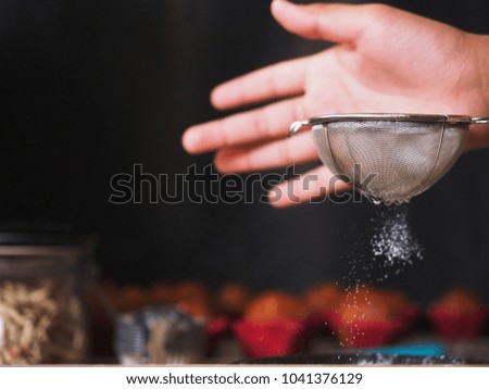 Colander. Stainless steel sieve, one hand in the corner ,making flour sifting for cooking. background hand blurred it good.   