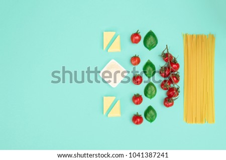 Italian pasta with tomatoes, grated parmesan and basil. Flat lay style, knolling concept with copy space.