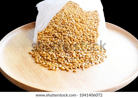 Seed wheat grains on wooden plate isolated