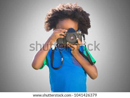 Digital composite of Boy against grey background with camera