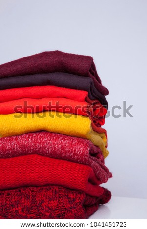 stack of folded knitwear on white background