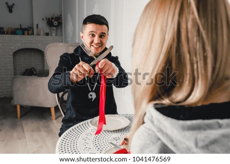 A young couple dining at the table in the room and have fun together