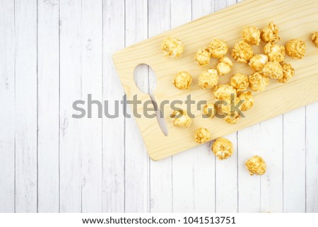 Entertainment or movie concept. Popcorns on a wooden board. Flat lay view.