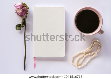 Desk Top with Cup of Coffee, Notebook, Dried Rose and Vintage Pearls
