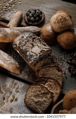 Breads with blackberry pie, nuts, seeds on a table