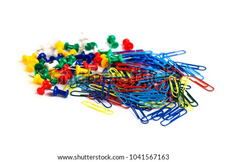 Bunch of colorful paper clips and tacks isolated on white background.