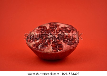 Pomegranate on a red background. Juicy pieces of pomegranate. Split pomegranate