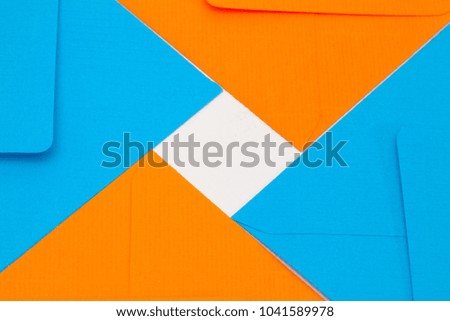 Pattern from blue and orange envelopes on the white table