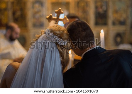 Happy stylish newlyweds in the ortodox church at wedding Royalty-Free Stock Photo #1041591070