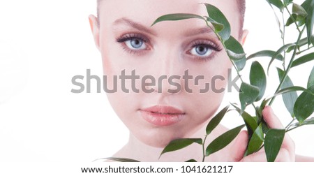 Beauty shoot. European, young, blue-eyed woman posing with fresh, green leaf.	