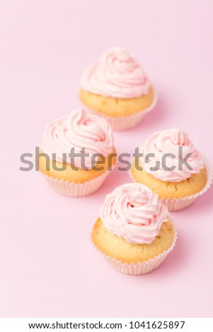 Cupcake decorated with pink buttercream on pastel pink background. Sweet beautiful cake for wedding or birthday greeting card or invitation.