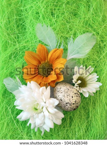 Easter still-life with flowers, eggs, feathers on a green sisal fiber with a sign
