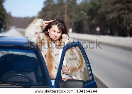 Young woman with her car in winter day