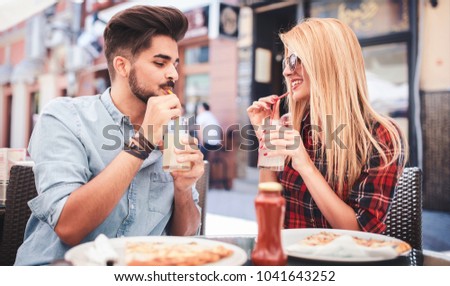 Dating in pizzeria. Handsome smiling couple enjoying in pizza, having fun together. Consumerism, food, lifestyle concept