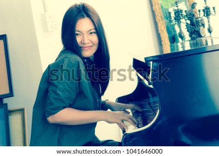 Portrait of Long Hair Beautiful Musician Woman is Playing The Piano in Living Room. Asian Caucasian Female Model Close Up Concept. Copy Space for Text. Vintage Style.