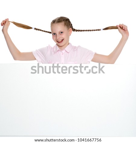 A beautiful little girl is pulling herself in pigtails. The concept of education, advertising, children's emotions. Isolated on white background.