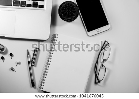 Top view of laptop, blank notebook, paper clips  and smart phone with white background and copy space.