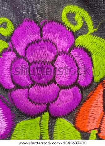 flower hand-embroidered in purple, mexican artisan work, background texture