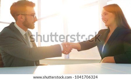 Friendly smiling business people  handshaking after pleasant tal