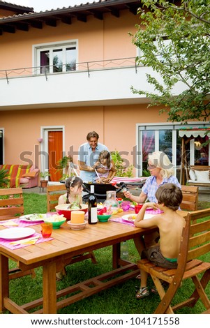 Family having a barbecue in the garden, eating