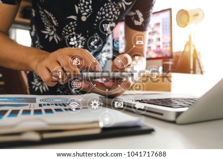 designer man using smart phone for mobile payments online shopping,omni channel,sitting on table,virtual icons graphics interface screen in morning light
