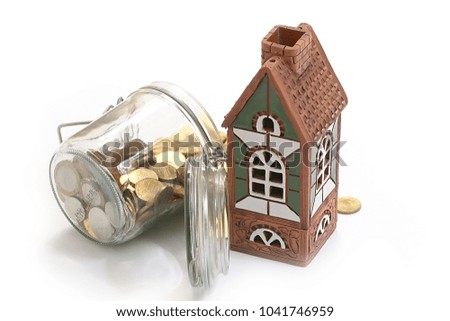 a beautiful house and metal rubles in a glass pot like an accumulation