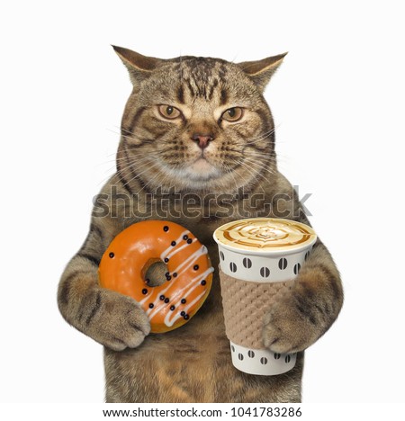 The cat holds a cup of coffee and orange glazed donut. White background. Royalty-Free Stock Photo #1041783286