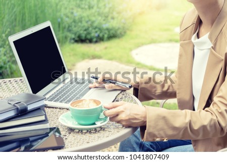 businesswoman do business use computer out of the office in the garden green and fresh air with black computer screen with clipping path