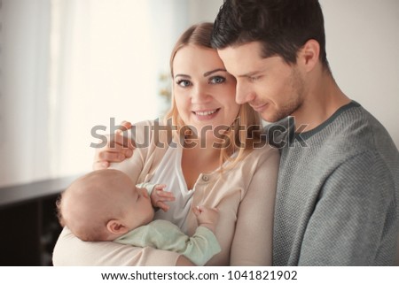 Young parents with sleeping baby at home