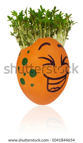 Hand painted easter egg in a funny smiley guy face and multicolored patterns with cress like hair. The watercress stylized for the hairstyle of the character. Egg in green and blue colors on a white