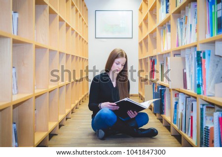 A girl siting on the library floor